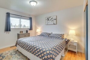 A bedroom with a bed, bedside tables, a window with curtains, a wall-mounted artwork, and a patterned rug. - 7 Mi to Dtwn: Family-friendly Abode in Seattle! (Seattle)