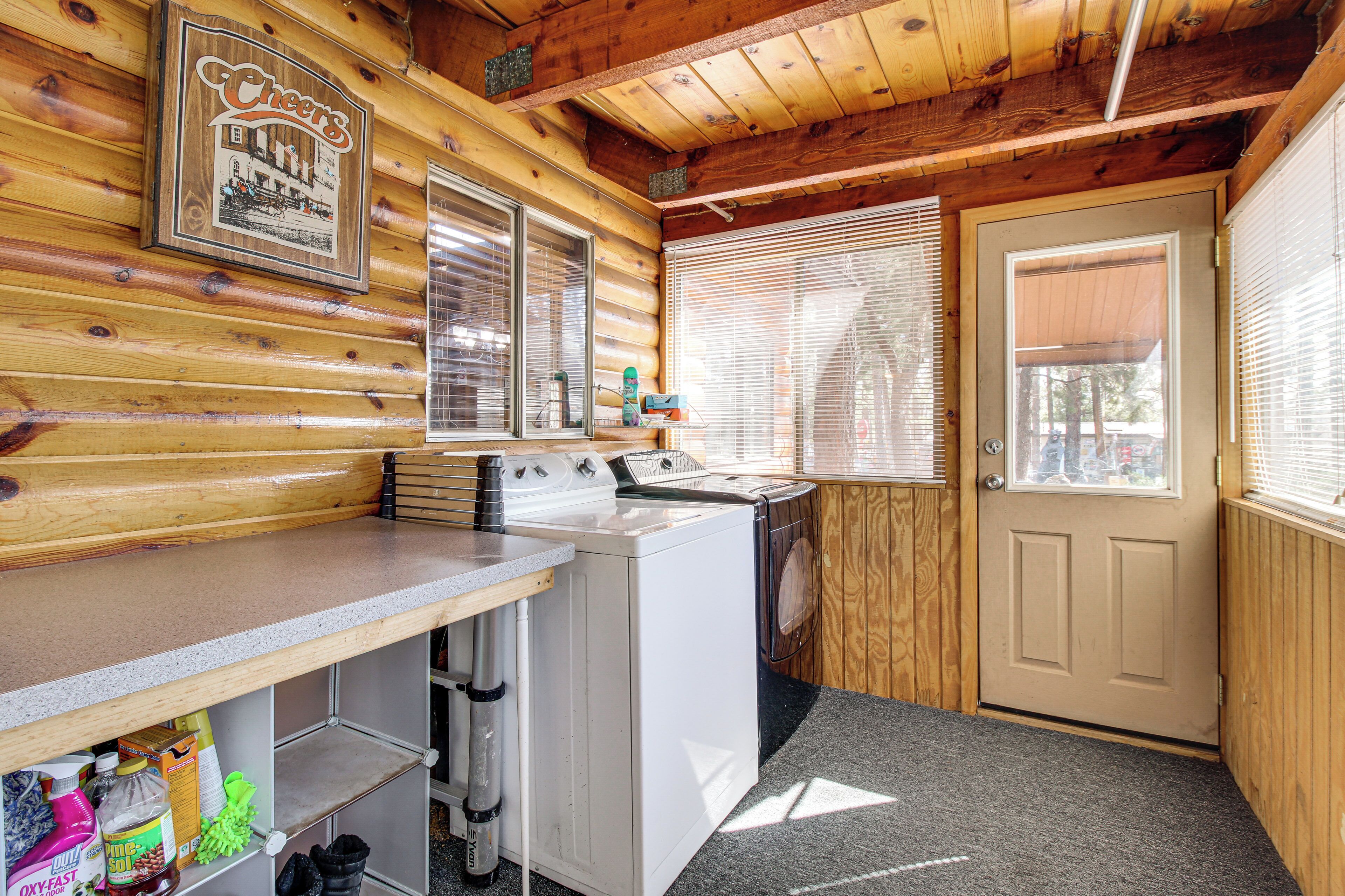 A cabin interior with a wooden interior, a washing machine, a sink, and a door with a window.