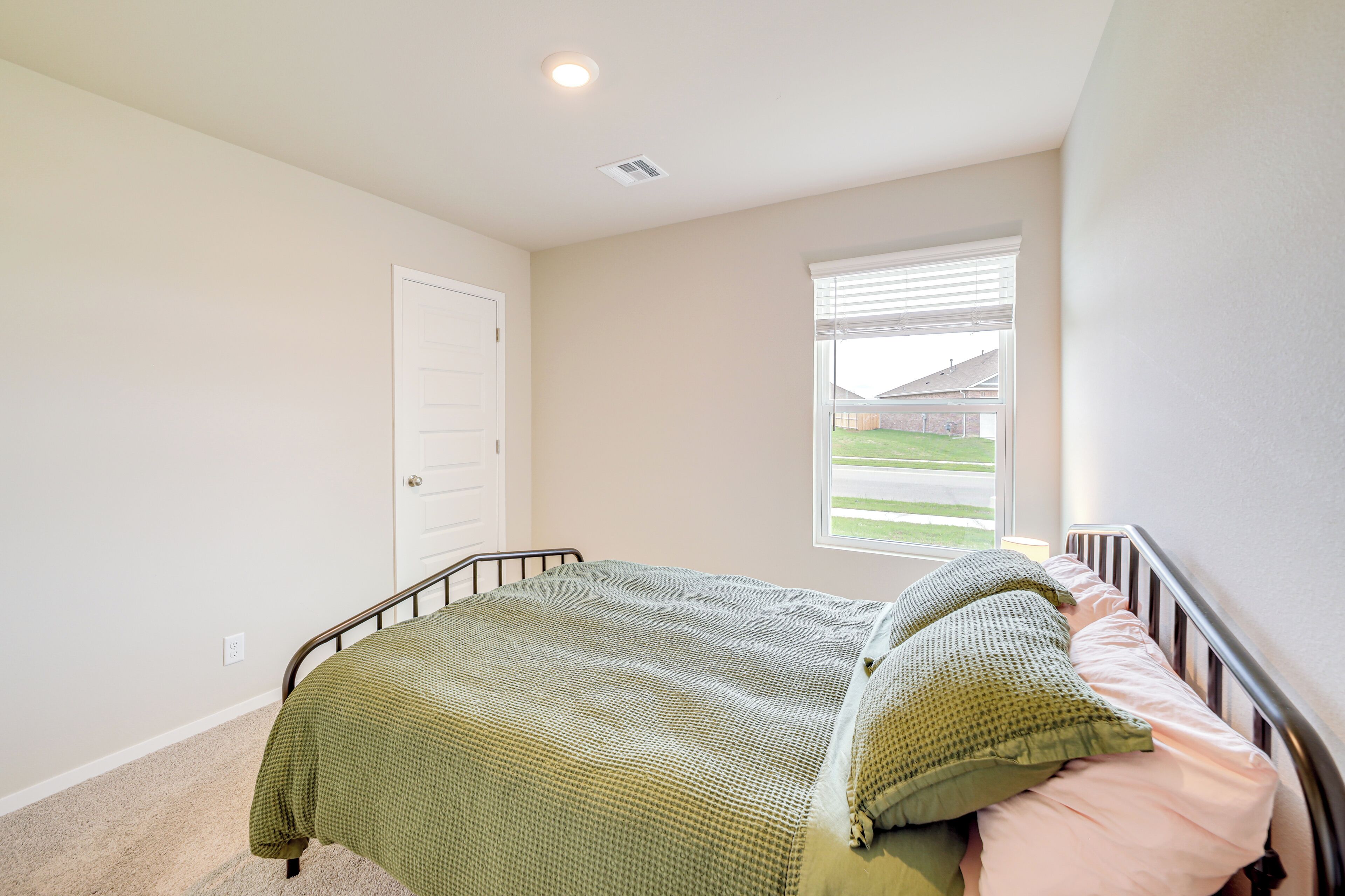 Un dormitorio con cama, ventana y puerta.