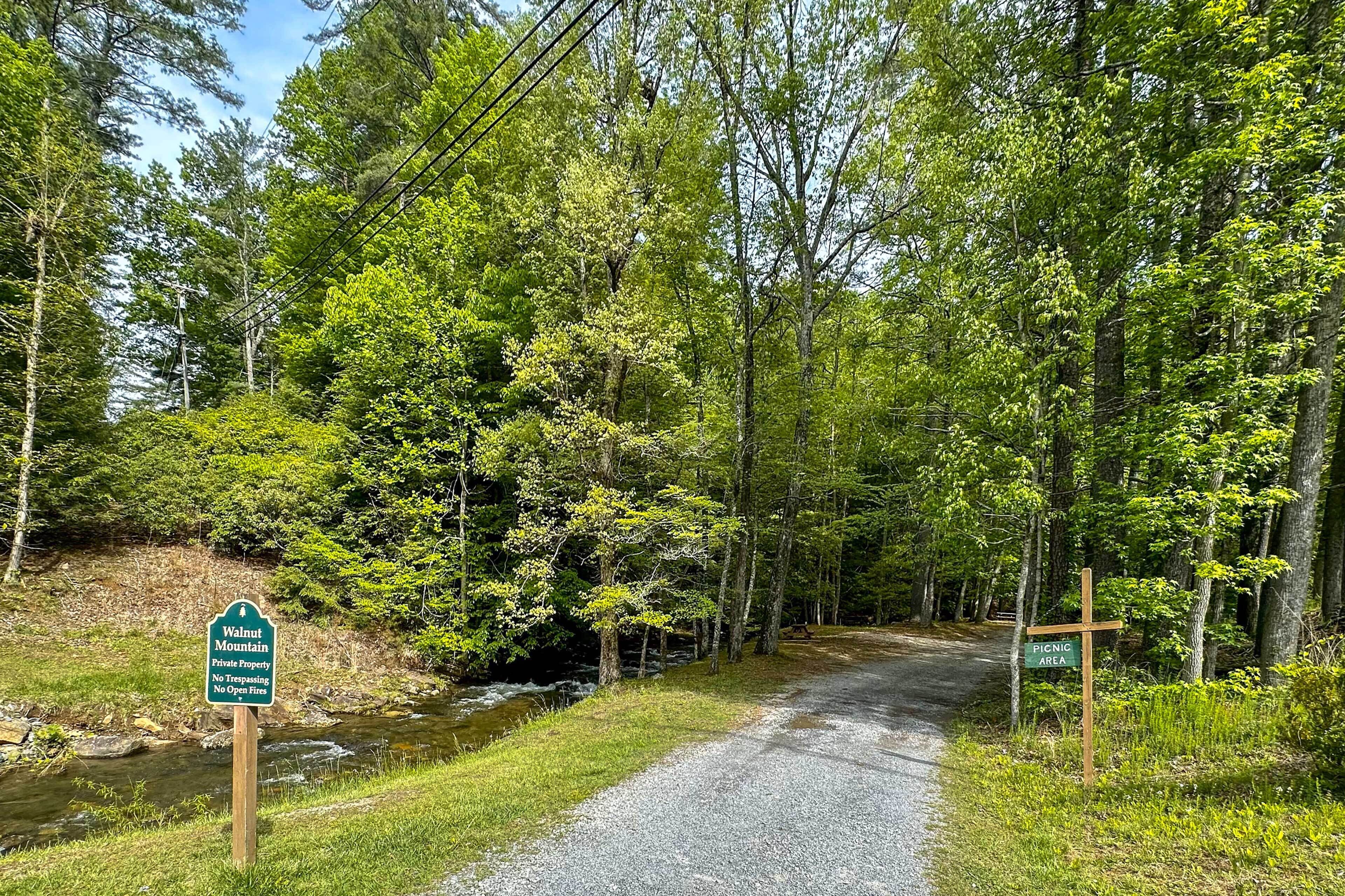 A gravel path leading through a forested area with signs indicating Walnut Mountain Private Property and a Picnic Area.