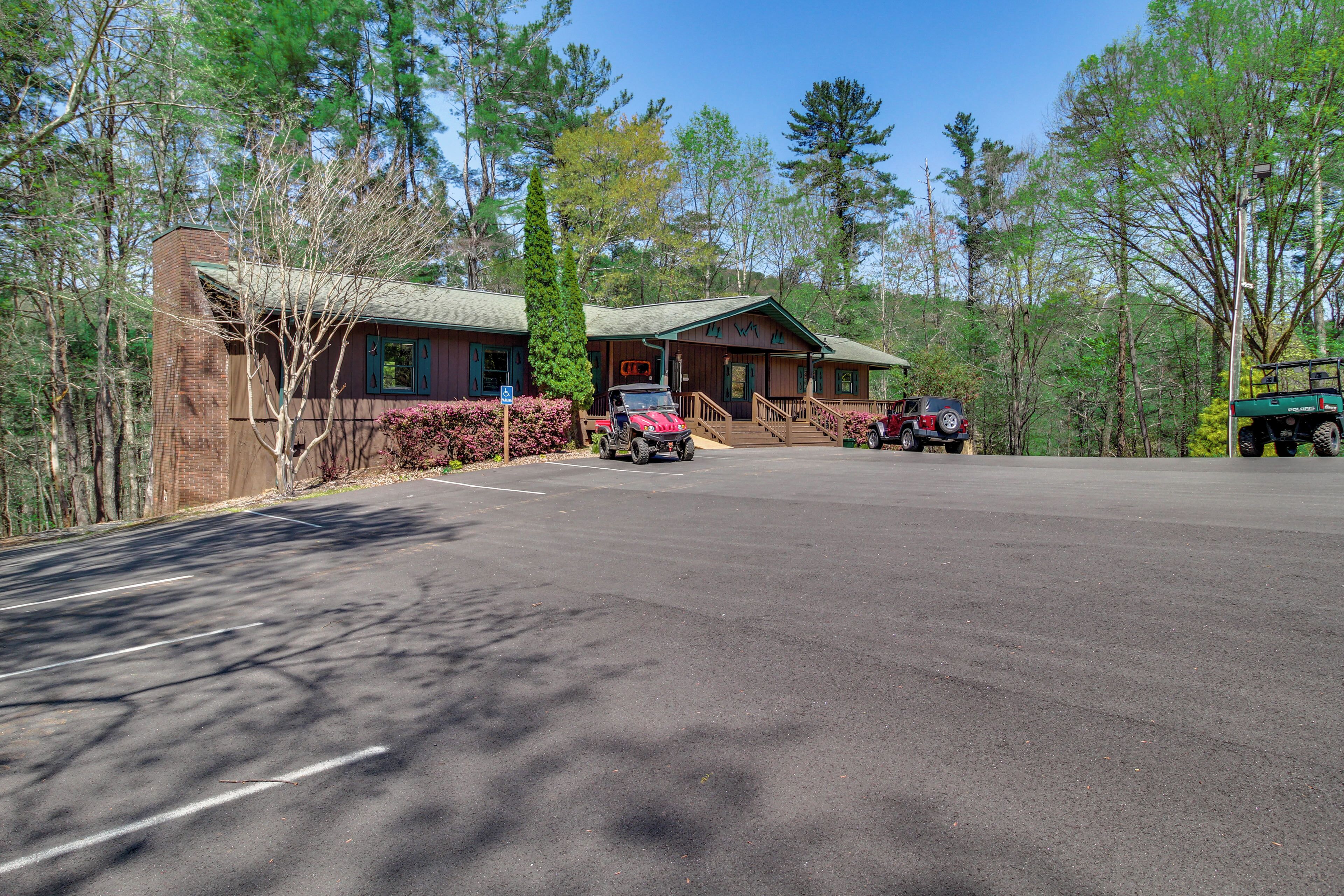 A lodge with a paved driveway, a brick building, and a green-roofed structure.