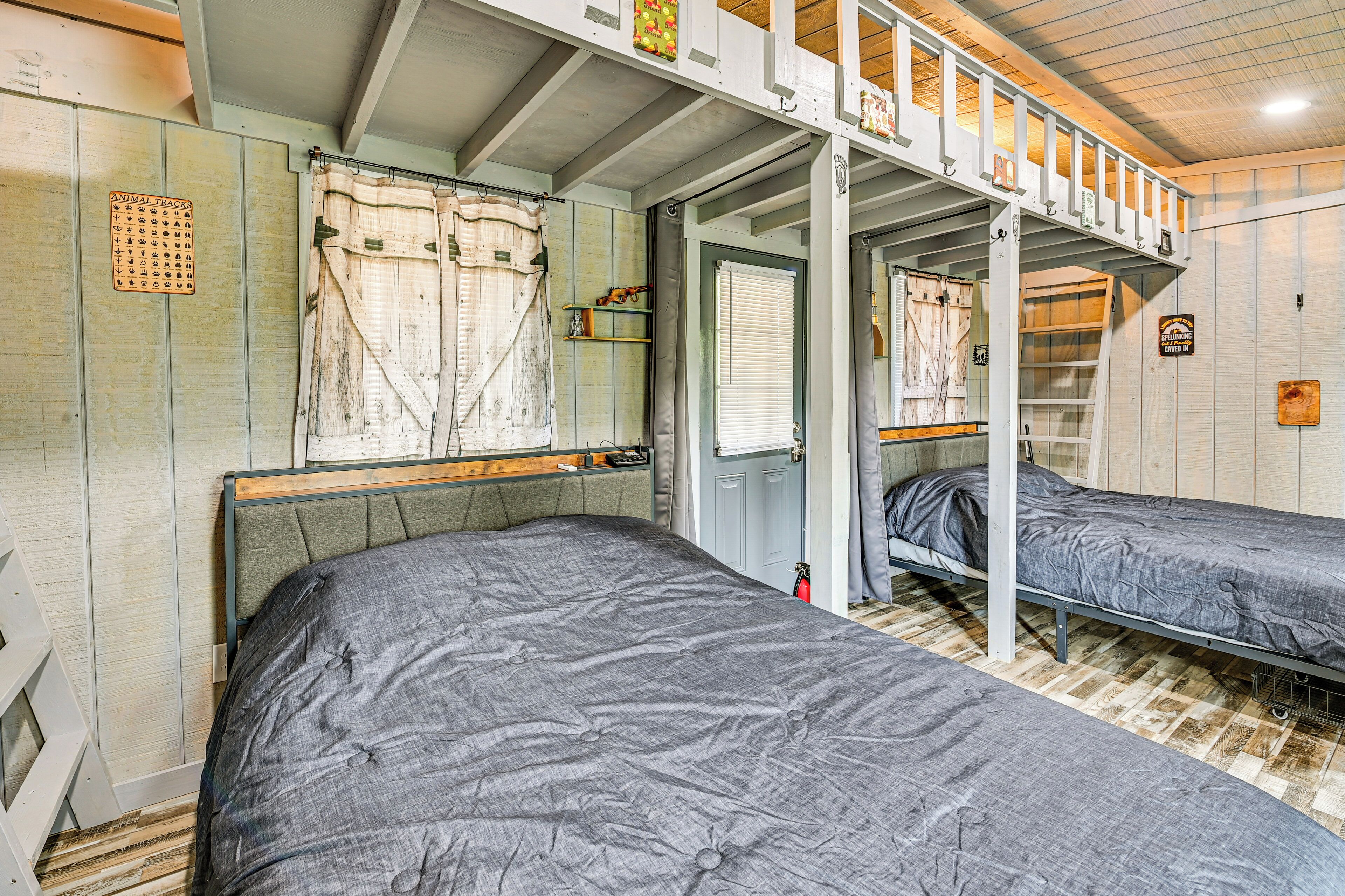 A room with two beds, a wooden ceiling, and a small window.
