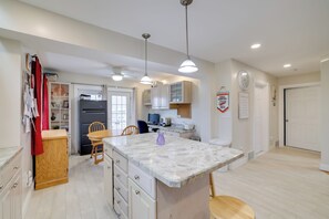 A modern kitchen with a marble island, wooden cabinets, and pendant lighting. - 1 Mi to Beach: Nature Paradise in Lake View! (Hamburg)
