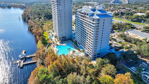 Ein Hochhaus-Hotel mit Pool, Anlegesteg und umliegender Bepflanzung.