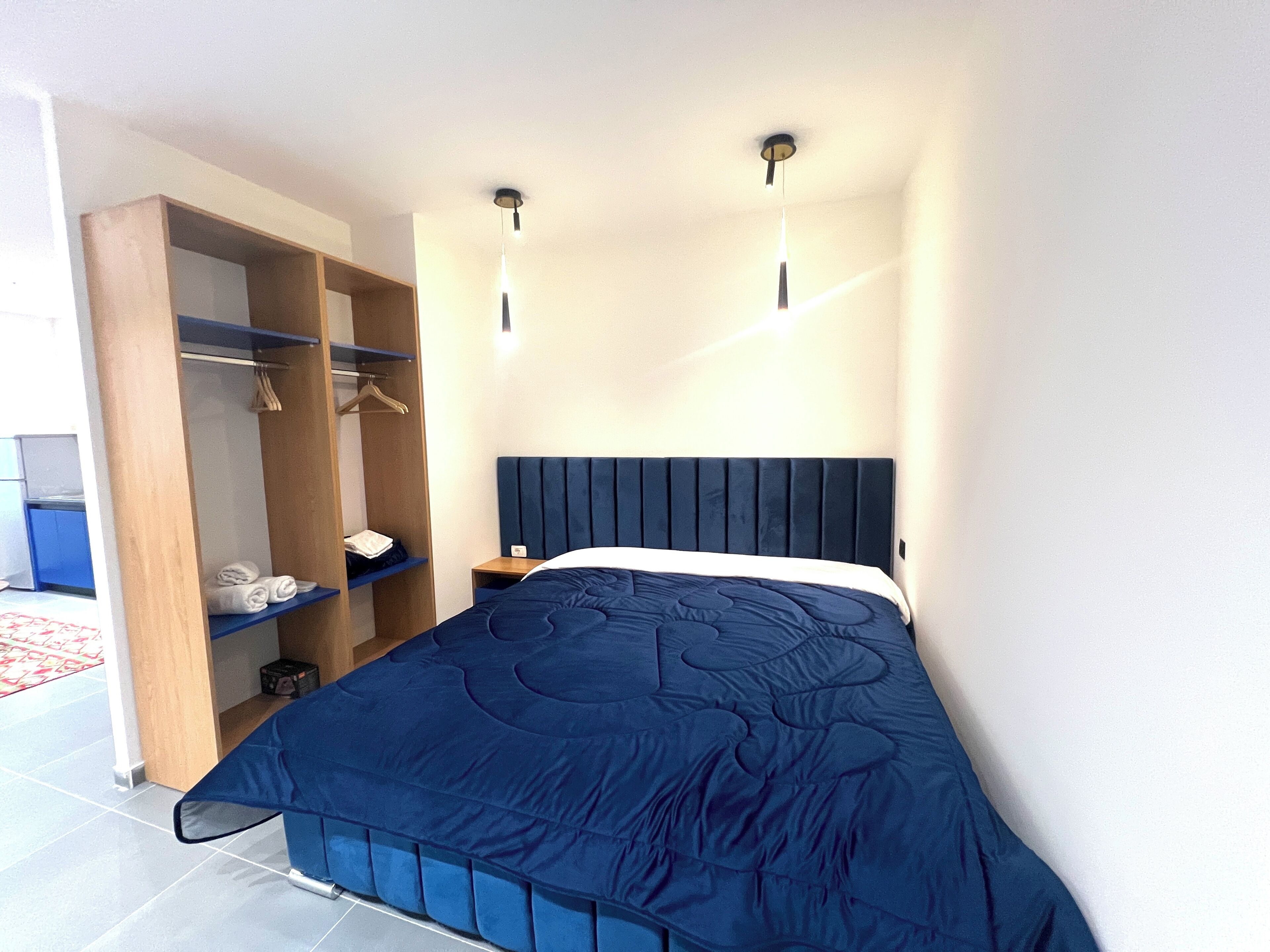 Een slaapkamer met een bed, een garderobe en een nachtkastje.