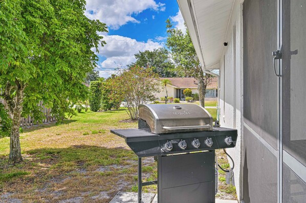 A barbecue grill in a backyard with a house in the background. - Tranquil Vacation Home, Hot Tub and Pool - 4 miles to Naples Beach! (Naples)