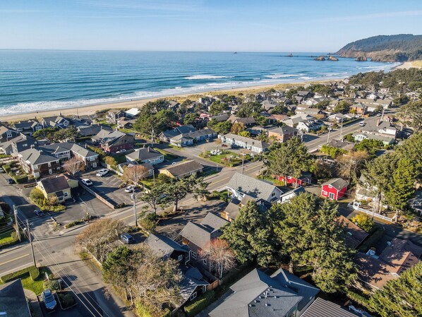 Una zona residencial con casas, una playa y un paisaje montañoso al fondo.