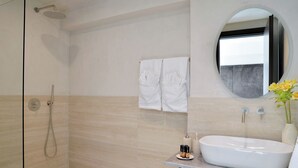 A modern bathroom with a shower, a sink, and a mirror.
