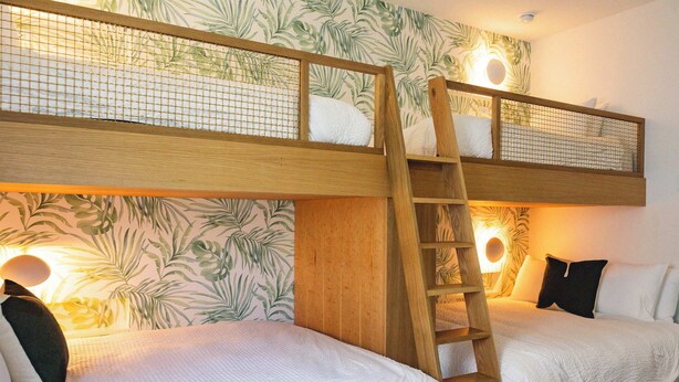 A bunk bed room with two beds, a wooden ladder, and wall-mounted lights. - The Shellstone House at Solaire Lunara Bay (Key West)
