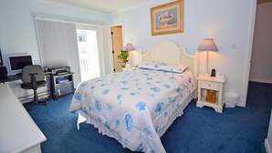 A hotel room with a bed, desk, computer, and a painting on the wall. - Sea Raider Iv 303 3 Bedroom Condo (Ocean City)