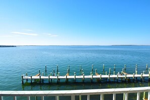 A waterfront dock extending into calm blue waters, with a clear sky above. - Thunder Island 14a 2 Bedroom Condo (Ocean City)