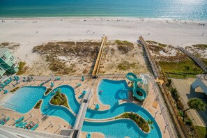 A beach resort with a large swimming pool, a water slide, and a beach area. - Phoenix Gulf Shores Ii 902 3 Bedroom Condo (Gulf Shores)