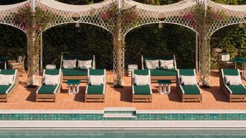 Een buitenzwembad, ligstoelen bij het zwembad