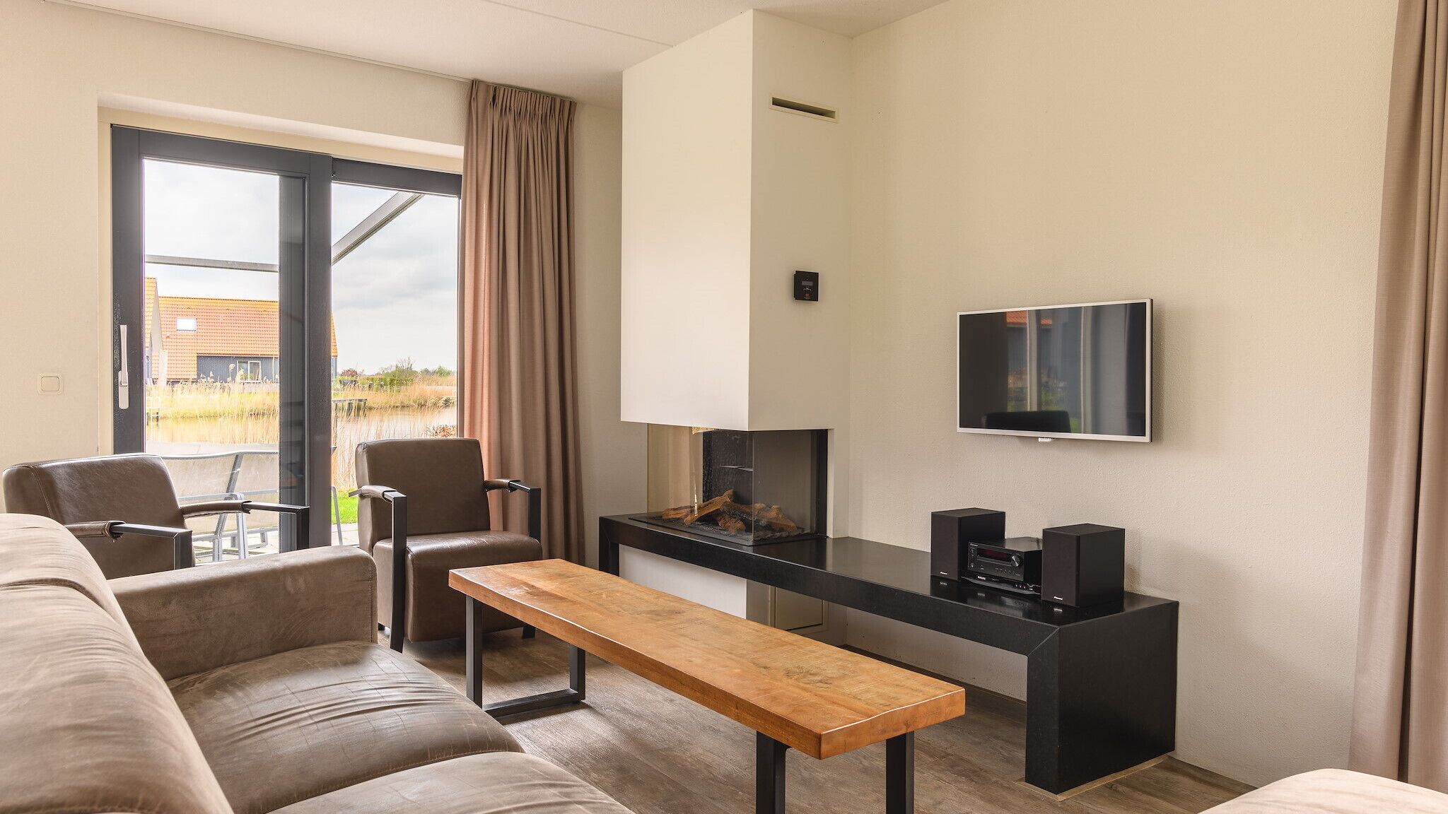 Un soggiorno moderno con un divano, una panca in legno, una TV e un camino.