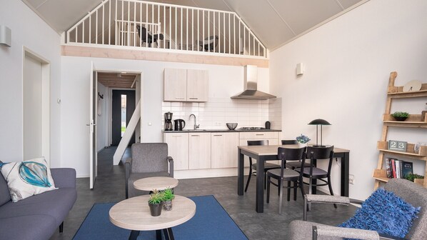 Ein modernes Apartment mit einer offenen Küche im Loft-Stil, einem Essbereich und einem Wohnzimmer.