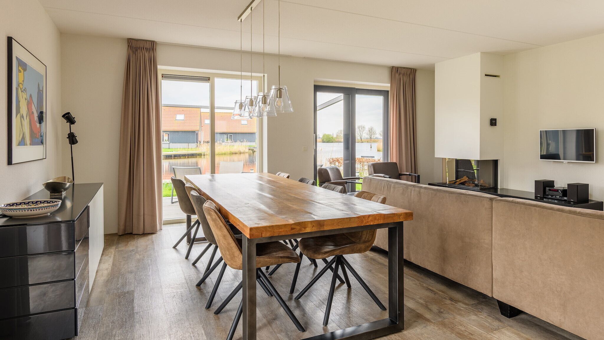 Une cuisine moderne avec une table en bois, des chaises et un téléviseur.