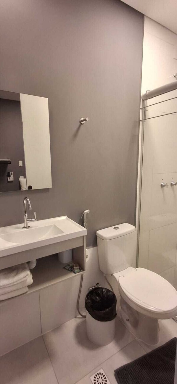 Ein modernes Badezimmer mit Waschbecken, Spiegel und Toilette in Weiß.