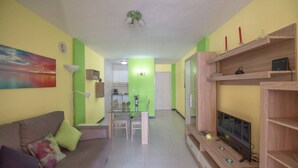 A living room with a sofa, TV, and wooden shelves. - Casa Angel - Puerto Naos (Puerto de Naos)