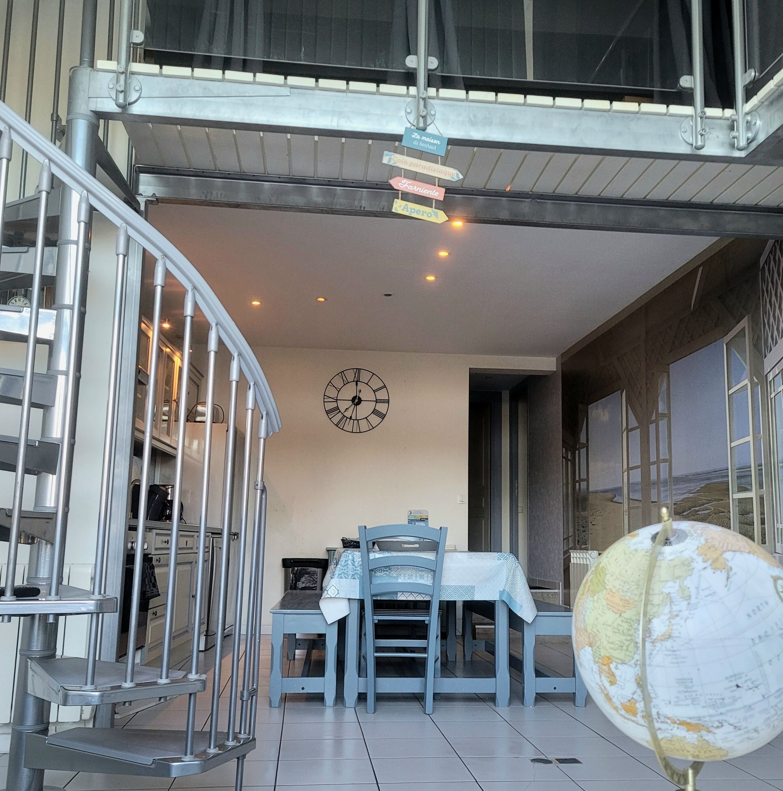 A dining area with a table and chairs, a clock on the wall, and a globe on a stand.