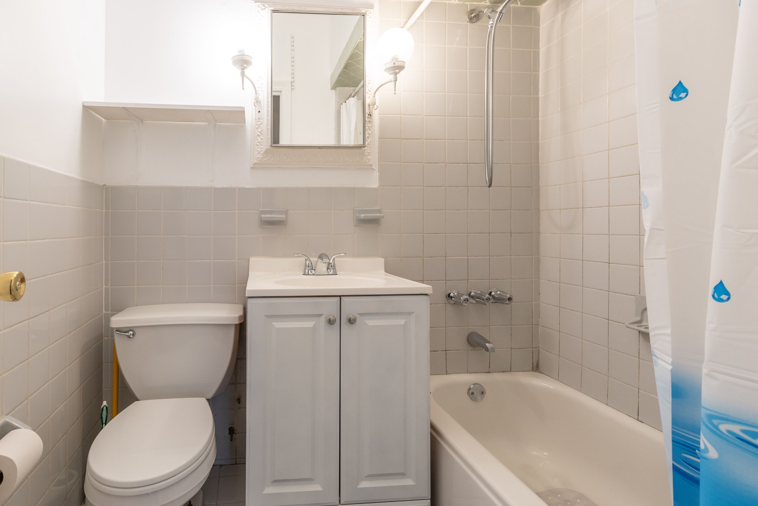 Ein Badezimmer mit Toilette, Waschbecken, Spiegel und Badewanne.