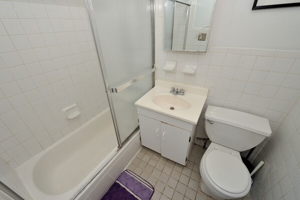 A bathroom with a bathtub, sink, and toilet.