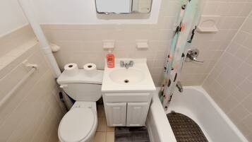 A bathroom with a toilet, sink, and bathtub.