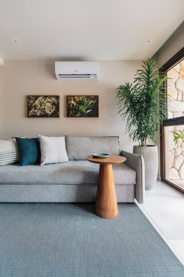A modern living room with a grey sofa, a wooden coffee table, and a large potted plant. - Maihai Porto de Galinhas (Ipojuca)