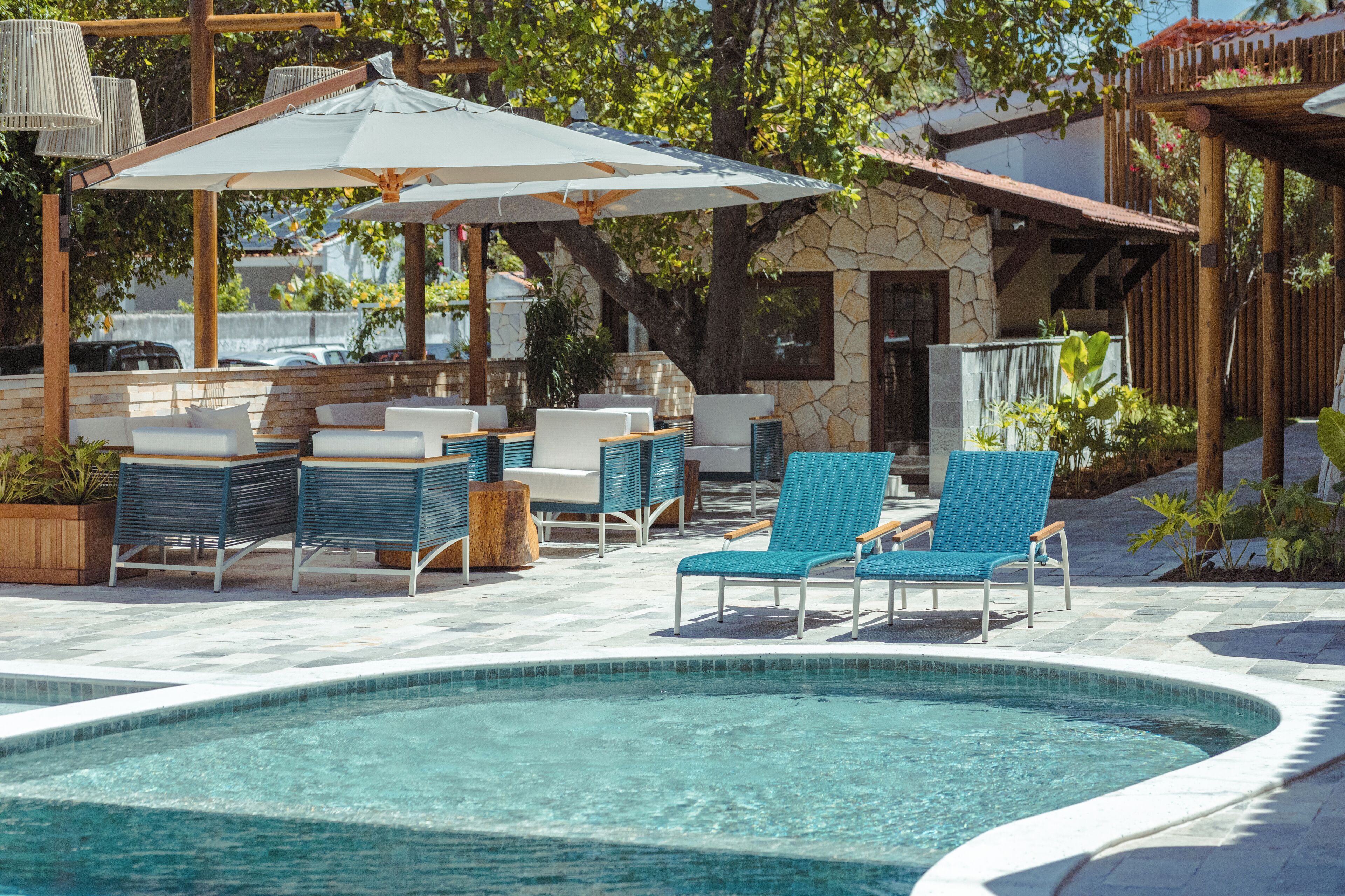 A pool area with lounge chairs and umbrellas.