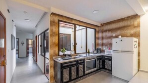 Uma cozinha moderna com bancada de mármore, eletrodomésticos de aço inoxidável e forno embutido.