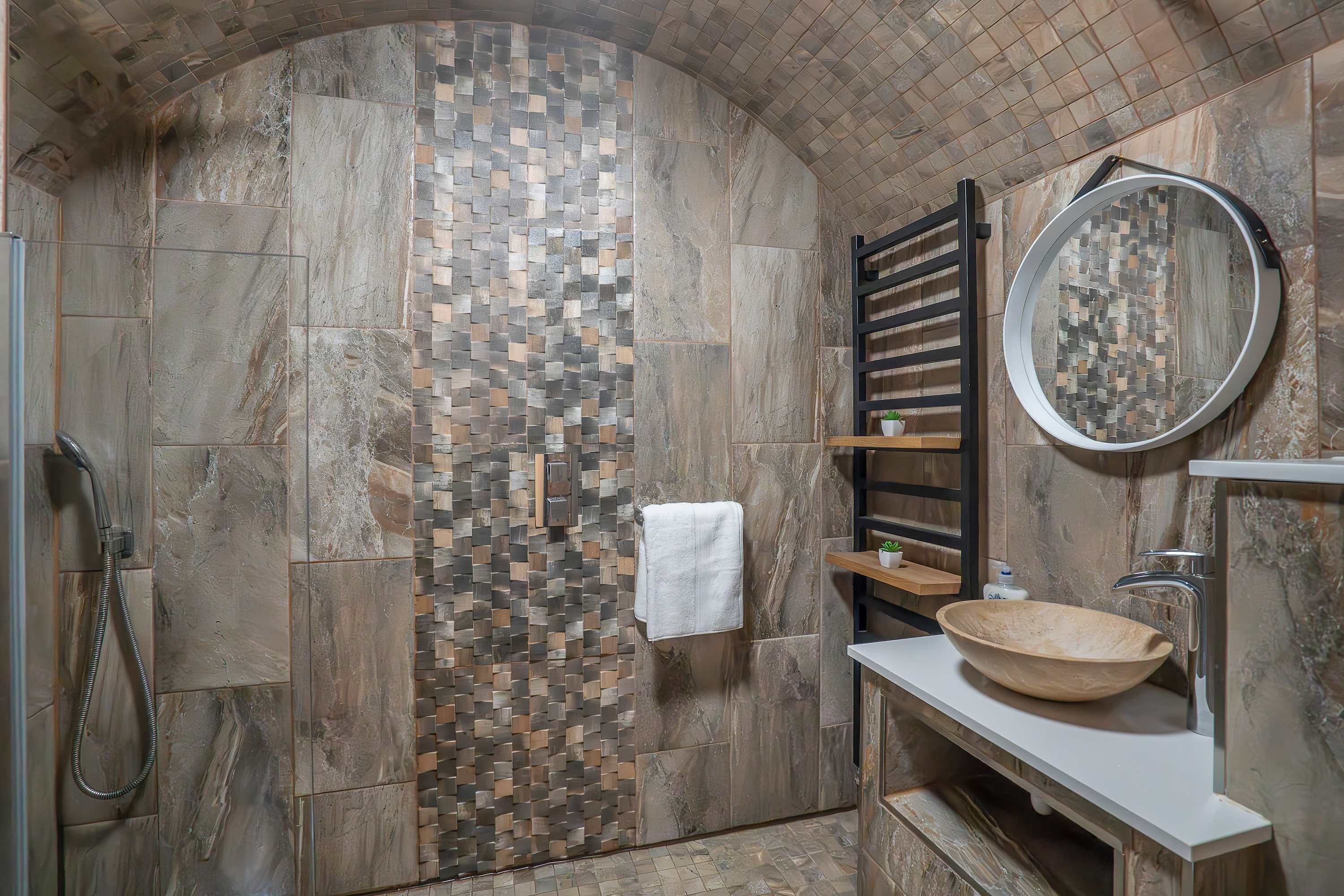 Ein Badezimmer mit Dusche, Waschbecken und Spiegel.
