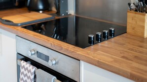 Une cuisine moderne dotée d’un plan de travail en bois, d’appareils électroménagers en acier inoxydable et d’un four encastré.