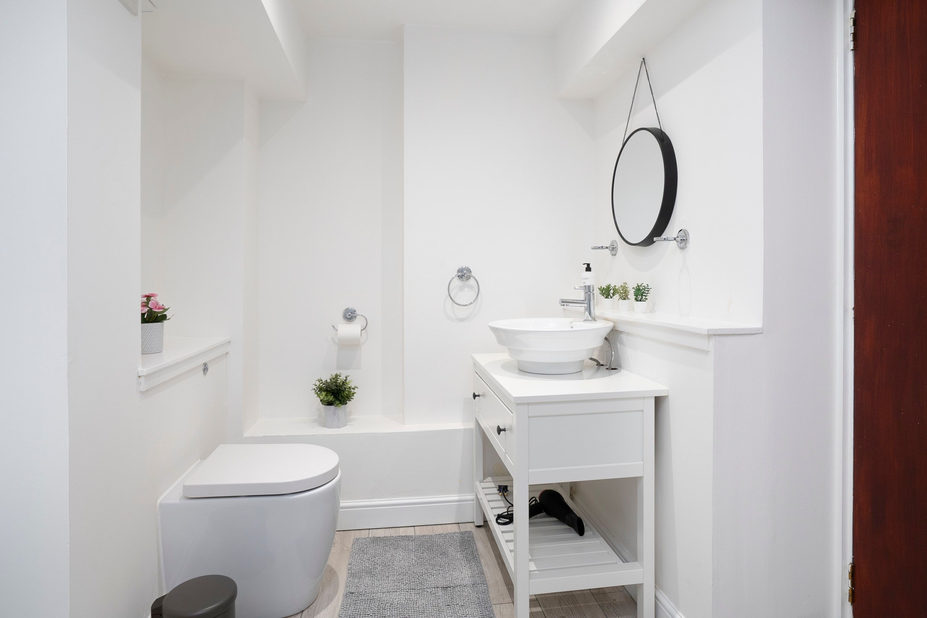 A modern bathroom with a toilet, sink, and shower.