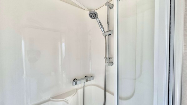 A shower with a handheld showerhead and a wall-mounted control. - Marton Mere - 3 Bedroom Caravan (Blackpool)