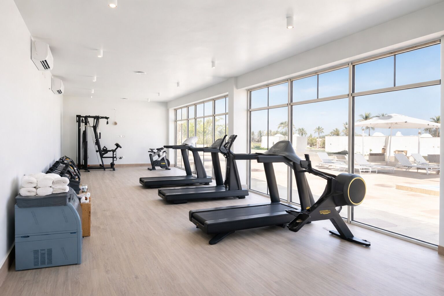 A gym with treadmills, exercise bikes, and weights.