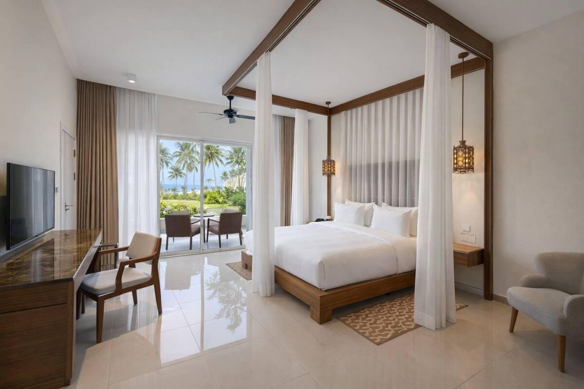 A modern hotel room with a large bed, a desk, and a television.