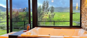 Cabin by the river with a view of the Cayambe snow-capped mountain