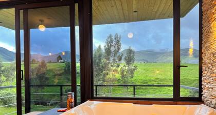 Cabin by the river with a view of the Cayambe snow-capped mountain