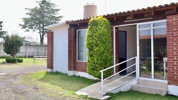 A house with a brick exterior, a white door, and a small porch.