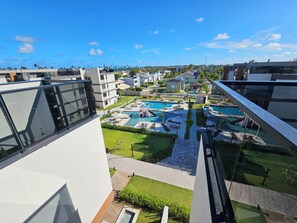 A modern hotel with a rooftop pool area, including a children's play area and lounge chairs. - Cais Eco Residência (Ipojuca)
