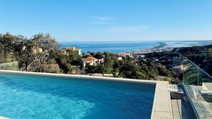 A swimming pool with a clear view of a coastal town and distant mountains. - Architect-designed house with sea and mountain views (Bastia)