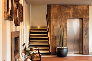 A staircase with a modern design, a potted cactus, and a door leading to an elevator. - BORGO SANTA GIULIA (Corte Franca)