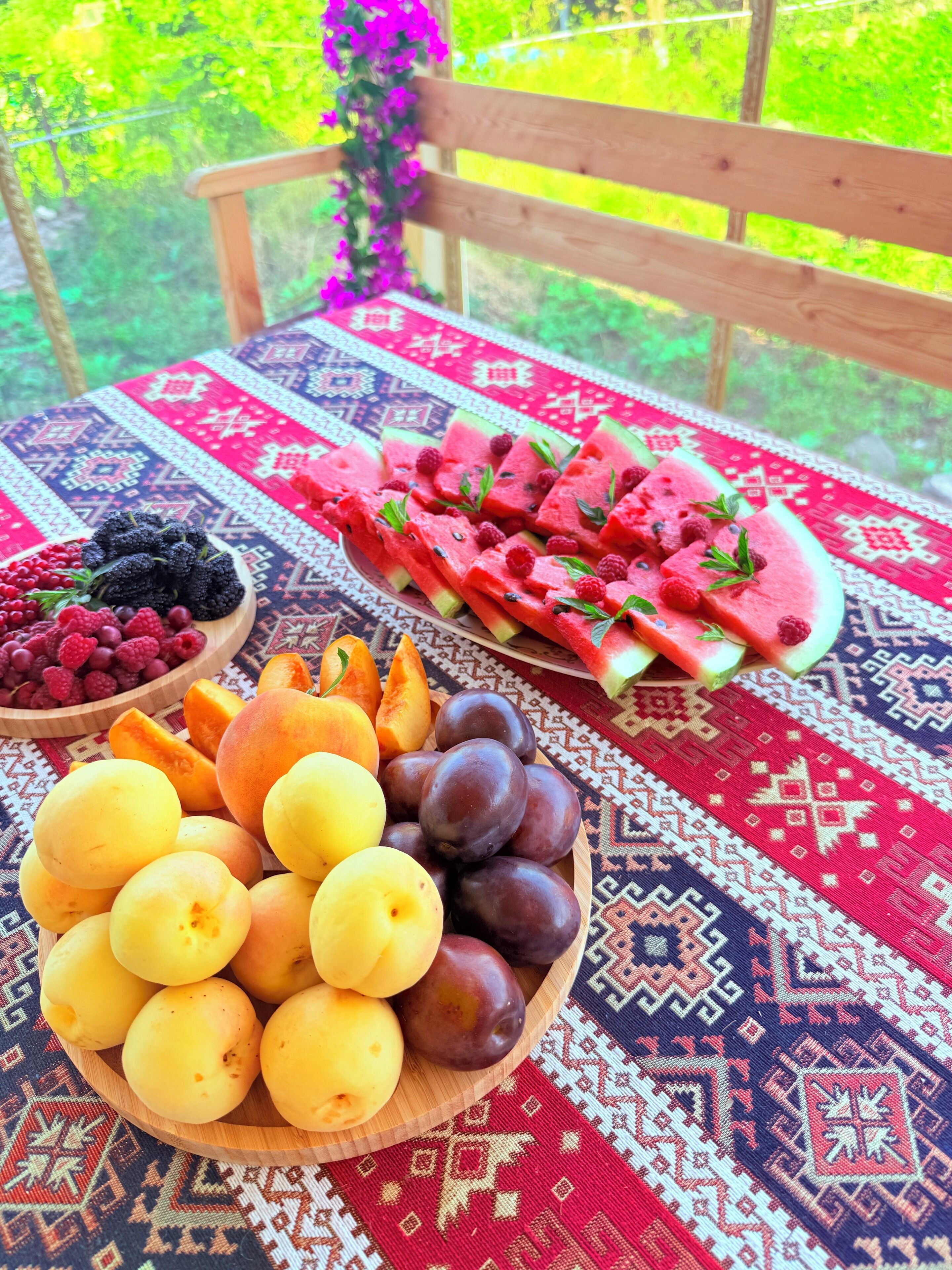 Taula amb fruita variada i un mantell estampat.