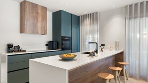 A modern kitchen with a central island, built-in appliances, and a minimalist design.