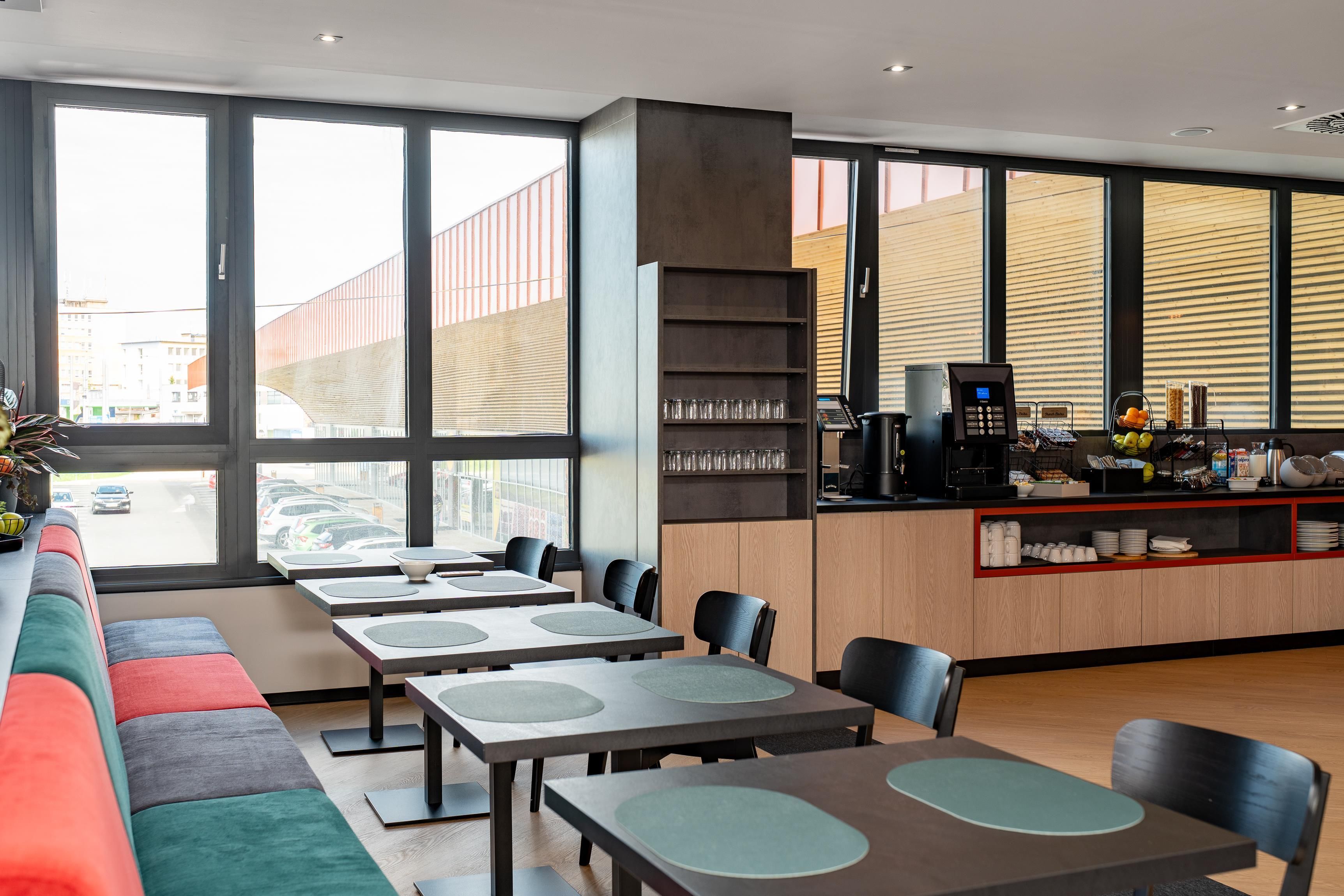 Un restaurante moderno con una barra larga, zona de estar y amplios ventanales.