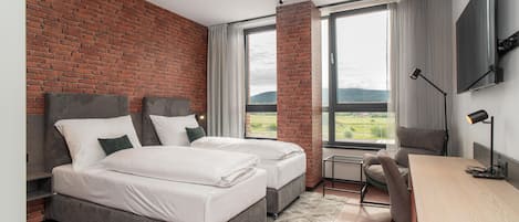 Una habitación de hotel moderna con dos camas, un escritorio y una silla.