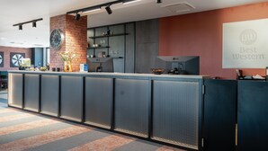 A modern reception area with a counter, shelves, and a clock. - Best Western Hotel Presov (Presov)