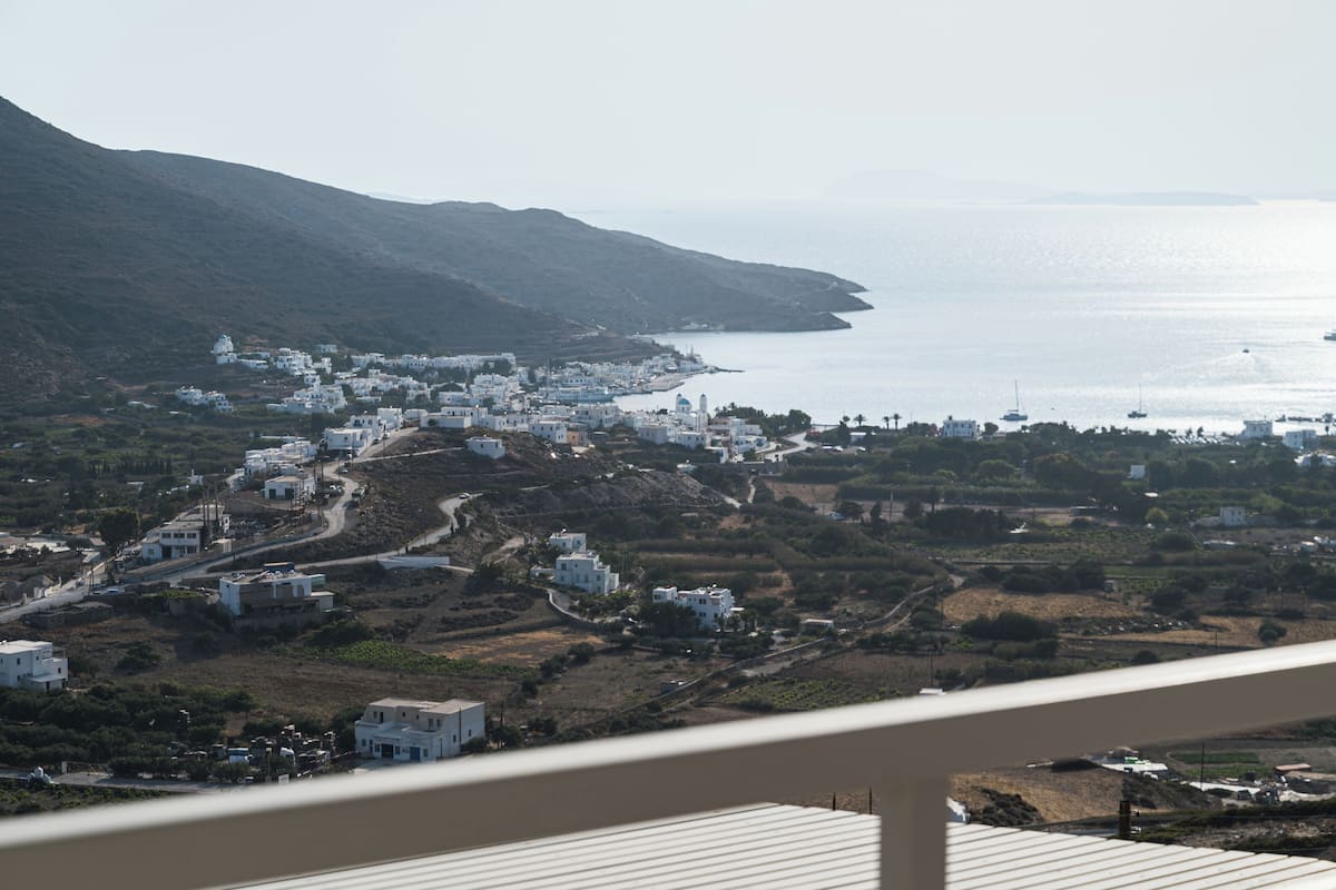 Une ville côtière aux bâtiments blancs, située au pied de collines et offrant une vue sur la mer.