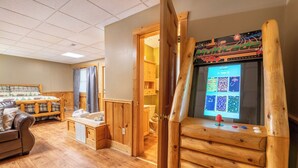 Een gezellige kamer met een houten kast, een houten bankje en een houten deur naar een badkamer.