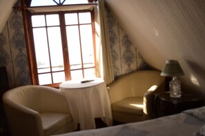 A room with a window, a chair, a small table, and a lamp. - Hotel Brighton (Valparaiso)