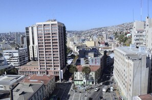 A high-rise building with multiple floors, surrounded by other buildings and a densely populated cityscape. - Hotel Brighton (Valparaiso)
